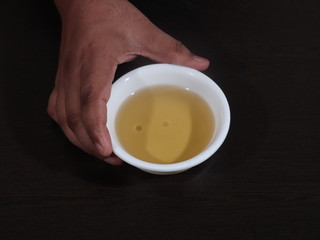 Olive oil on a wooden background, Fresh Olive Oil in White Bowl on Wooden Background, Olive in White Bowl on Hand in Wooden Background, Olive Oil