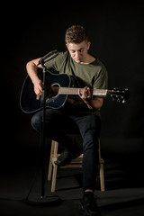 Guy in studio play on acoustic guitar