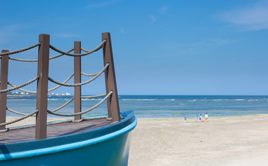 Boat Docked. Ocean Beach with Family in Background. Vacation. Family Time. Family Bonding. Parent and Child. Children. Mom, Dad, Kids, Grandparent. Family Outing. Parents and Children. Beach Coast.
