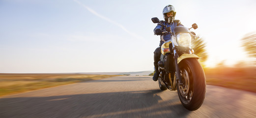 Obraz premium motocyklista na autostradzie z otwartym hełmem cieszy się osobistą wolnością bycia samemu.