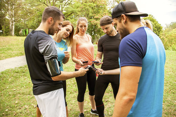 crossfit friends after running training and exercise compare their success with an app on their...