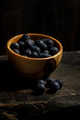 Fresh plums in a wooden bowl of handmade.
