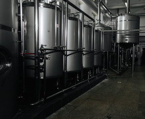 Modern brewery and equipment machinery tools for alcohol production. Steel vats or tanks and stainless pipes.