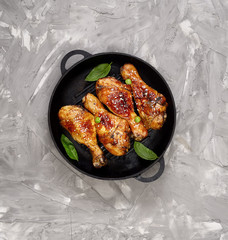 Fried chicken drumstick with sesame in a frying pan