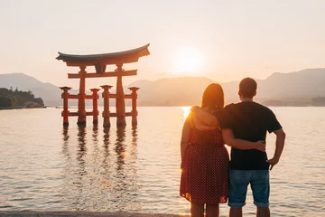 Fototapeten amazing sundown view to miyajima floating torii, Japan © jon_chica