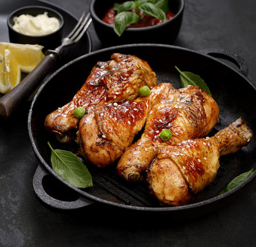 Fried chicken drumstick with sesame in a frying pan