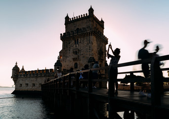 Long exposure backlit tourists at Belem Tower, or the Tower of St Vincent, a fortified 17th-century...