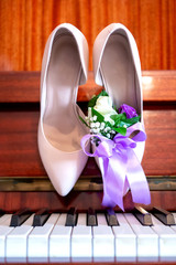 bride's shoes on the piano, bride's bouquet. wedding attributes.