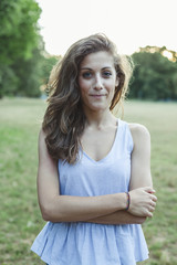 Portrait of beautiful young woman in park at sunset during summer