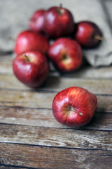 Fresh red apples on the wooden background with sack.selective focus. blurred background