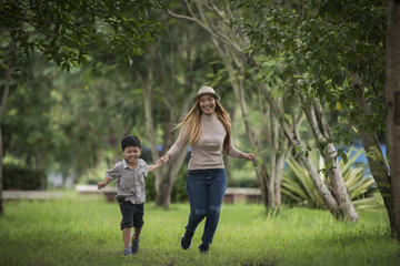 Portrait of mother and son happy walking together in the park holding hand. Family concept.