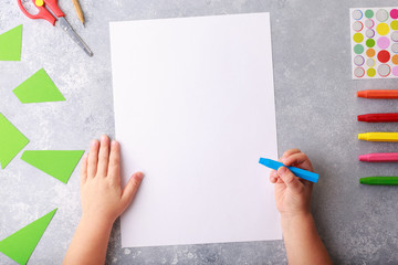 Child draws a pencil drawing empty space colorful grey background top view
