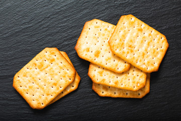 Food appetizer salted Crackers on black slate board with copy space