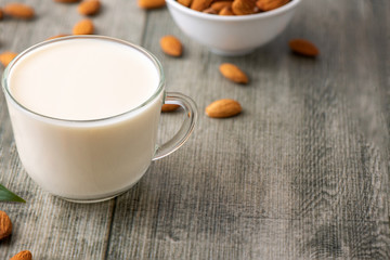 Almond milk with almond on a gray wooden table