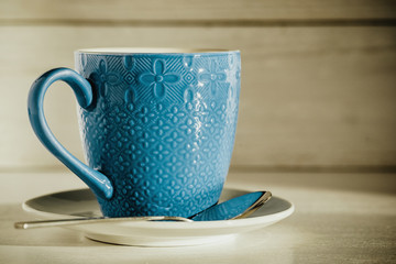 coffee in a blue cup on a light wooden background