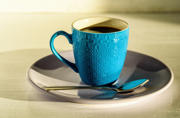 coffee in a blue cup on a light wooden background