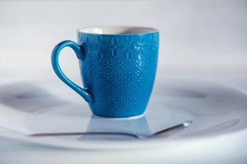 coffee in a blue cup on a light wooden background
