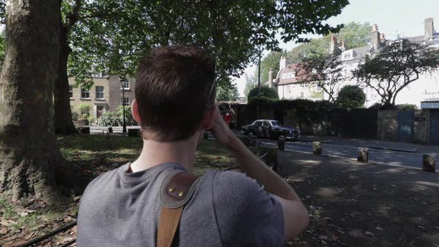 Orbit Zoom Into Man Taking A Photo Of Classic Car In Rural London Village. UK Day Time Sunny.