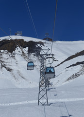 Fototapeta na wymiar Gondola lift ( cable car ) with tower and station over snow of mountain alps, transpotation from grindelwald to First peak Switzerland Europe
