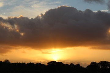 Fototapeta na wymiar Sunrise between forest and clouds