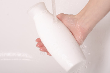 White bottle gel shower in hands water bath cosmetic care body