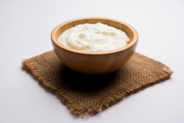 Plain curd or yogurt or Dahi in Hindi, served in a bowl over moody background. Selective focus