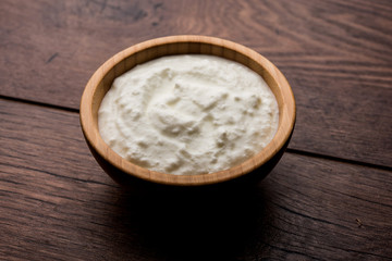 Plain curd or yogurt or Dahi in Hindi, served in a bowl over moody background. Selective focus