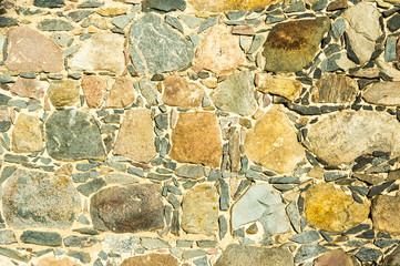 Texture of a wall of stone blocks illuminated by the sun