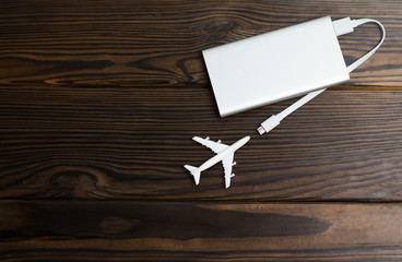 Plane and battery on dark wooden background. Electric plane or green plane concept. Copyspace.