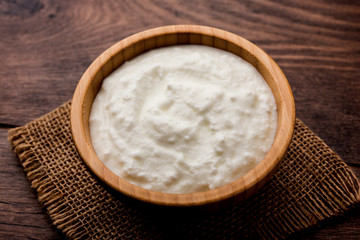 Plain curd or yogurt or Dahi in Hindi, served in a bowl over moody background. Selective focus