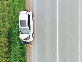 aerial view of broken car at roadside in the middle of nowhere