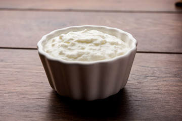 Plain curd or yogurt or Dahi in Hindi, served in a bowl over moody background. Selective focus