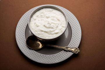 Plain curd or yogurt or Dahi in Hindi, served in a bowl over moody background. Selective focus