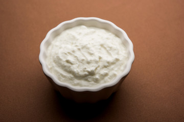 Plain curd or yogurt or Dahi in Hindi, served in a bowl over moody background. Selective focus