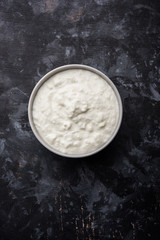 Plain curd or yogurt or Dahi in Hindi, served in a bowl over moody background. Selective focus