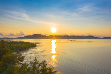 aerial view sunrise behine the mountain near the shipyard