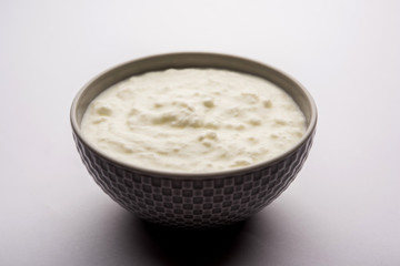 Plain curd or yogurt or Dahi in Hindi, served in a bowl over moody background. Selective focus