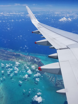Airplane wing view above the Caribbean sea.