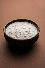 Plain curd or yogurt or Dahi in Hindi, served in a bowl over moody background. Selective focus