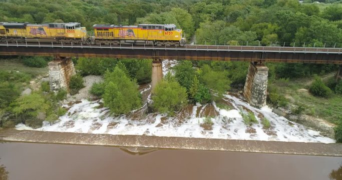 Aerial of fright train passing over the flooded Onion Creek in Buda, Texas as it carries it's cargo over the dangerous waters.