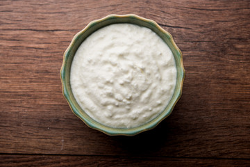 Plain curd or yogurt or Dahi in Hindi, served in a bowl over moody background. Selective focus