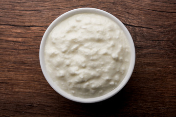 Plain curd or yogurt or Dahi in Hindi, served in a bowl over moody background. Selective focus
