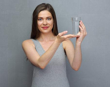 Smiling young woman with long hair holding water glass.