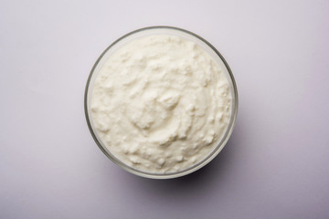 Plain curd or yogurt or Dahi in Hindi, served in a bowl over moody background. Selective focus