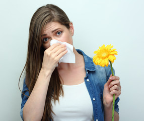 Woman with allergic reaction holding flower and paper tisue.