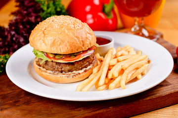Tasty beef burger and french fries on white plate. Close up