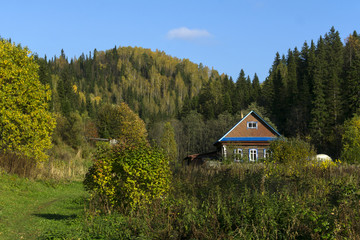 small farm in a beautiful autumn valley among wooded hills