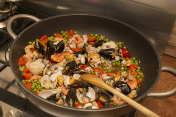 horizontal image of a pan on fire during the preparation of the paella