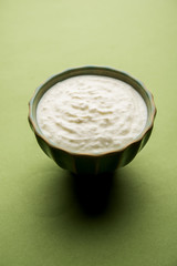 Plain curd or yogurt or Dahi in Hindi, served in a bowl over moody background. Selective focus