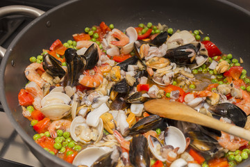horizontal image of a pan on fire during the preparation of the paella